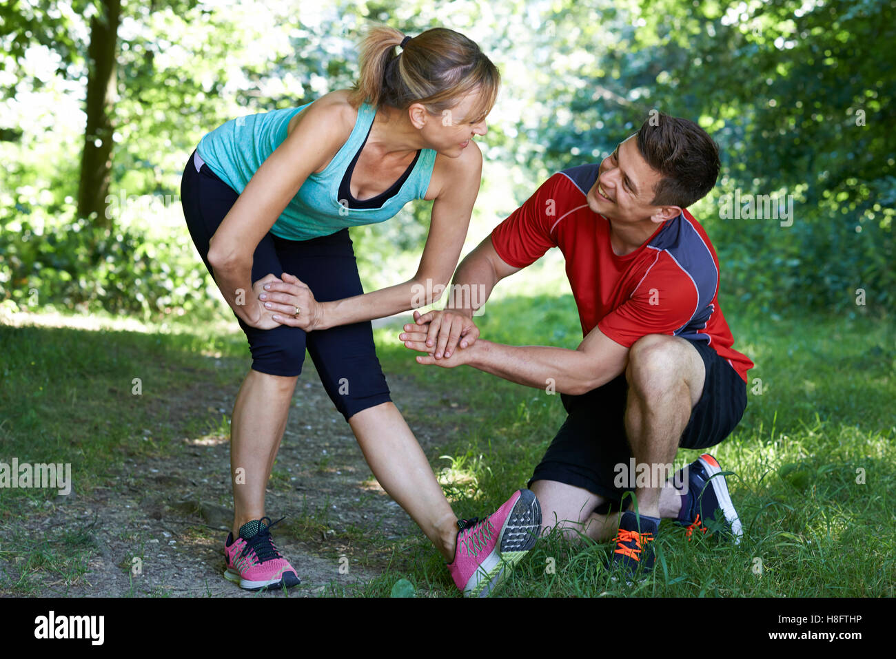 Mujer madura Hacer ejercicio con un entrenador personal en Park Foto de stock