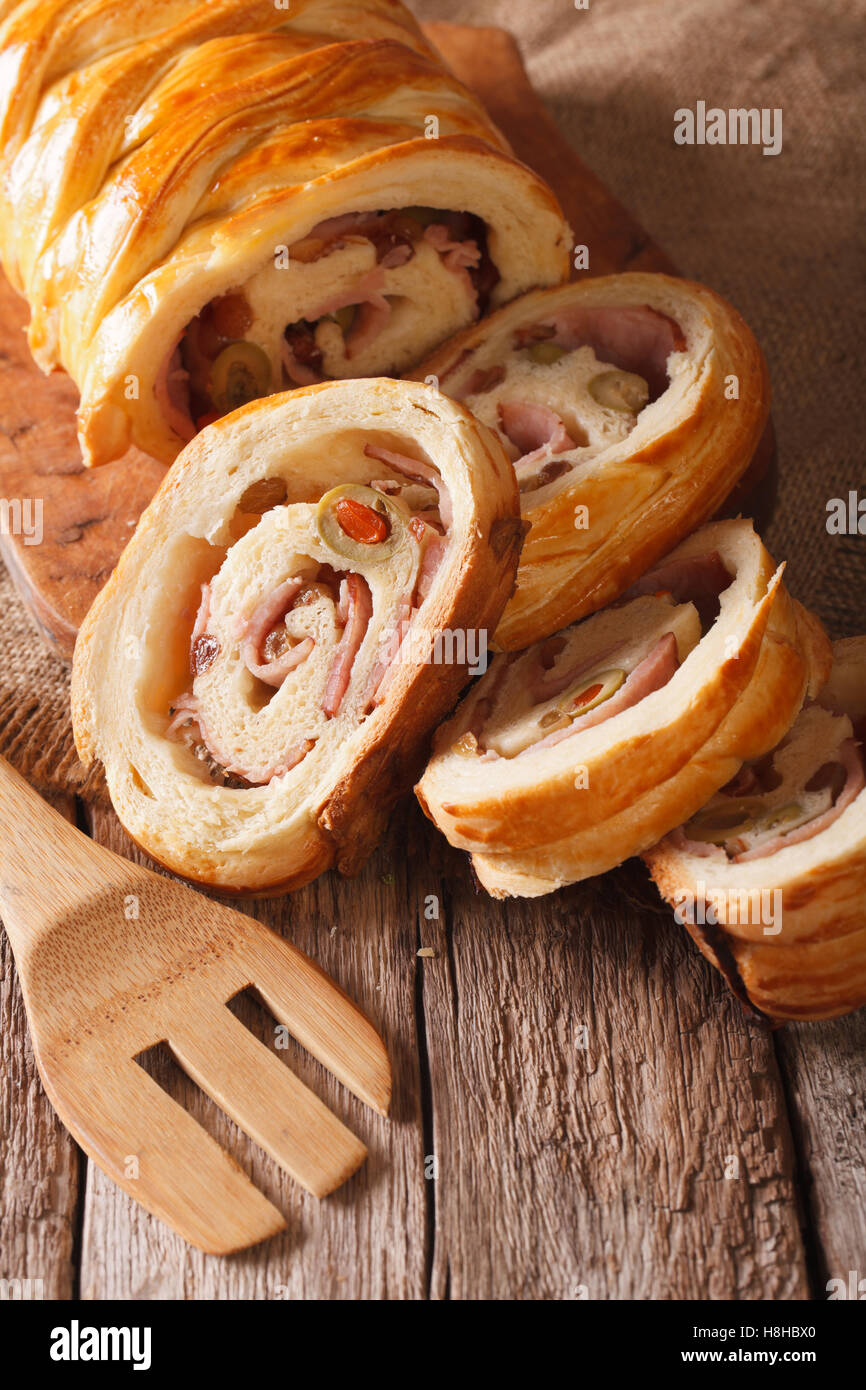 Pan de Jamón venezolano con aceitunas y pasas de cerca en la tabla vertical. Foto de stock