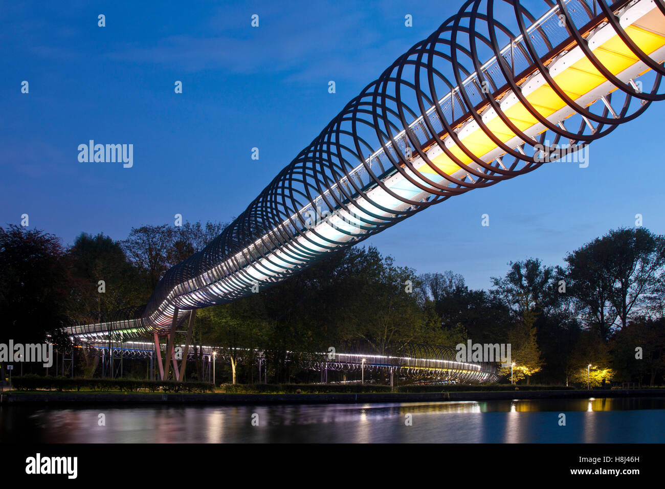 Alemania, Oberhausen, iluminado Puente peatonal Slinky salta a la fama, también llamado puente a través del canal Rhein-Herne Rehberger Foto de stock