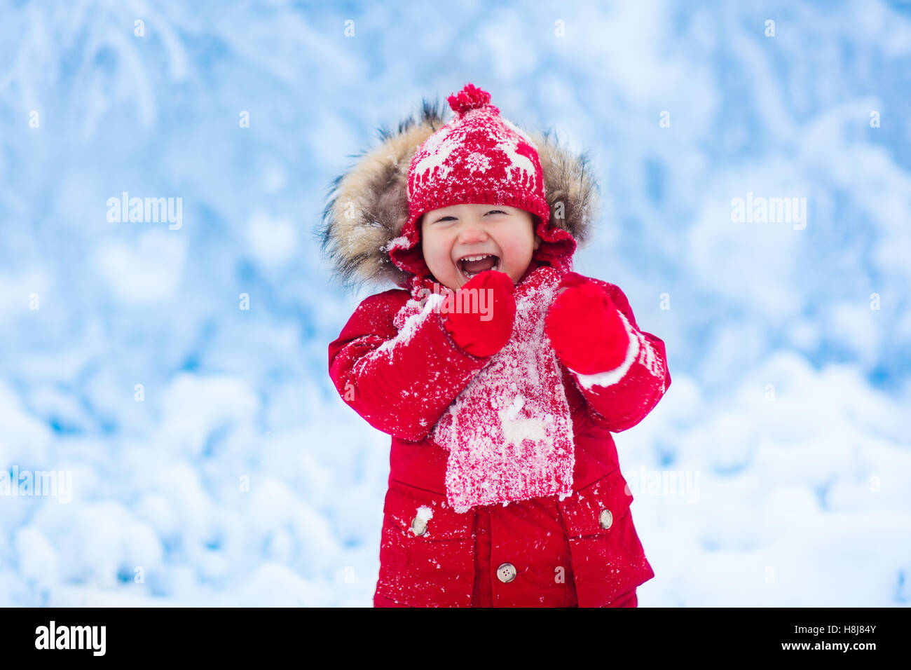 Deshonestidad Artístico miércoles Bebé jugando con nieve en invierno. Niño pequeño muchacho en la chaqueta  roja y sombrero de reno de Navidad atrapar los copos de nieve en Winter  Park Fotografía de stock - Alamy