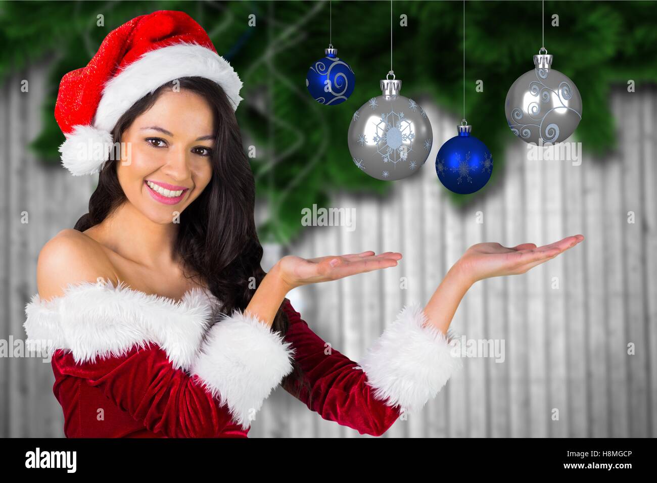 Bella mujer en santa traje mostrando bolas de navidad Foto de stock