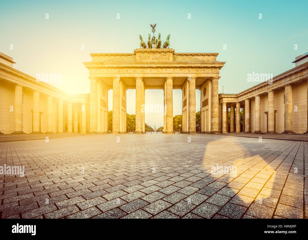 Vista clásica de la famosa Puerta de Brandenburgo en dorado al amanecer, la luz de la mañana en el centro de Berlín, Alemania Foto de stock