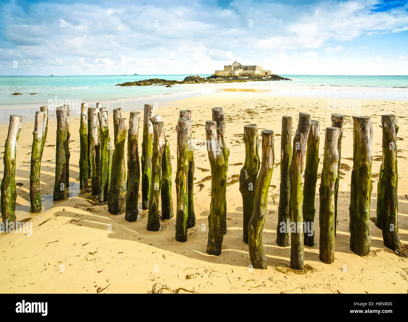 Saint Malo Beach, Fort National y postes de madera durante la marea baja. Brittany, Francia, Europa. Foto de stock