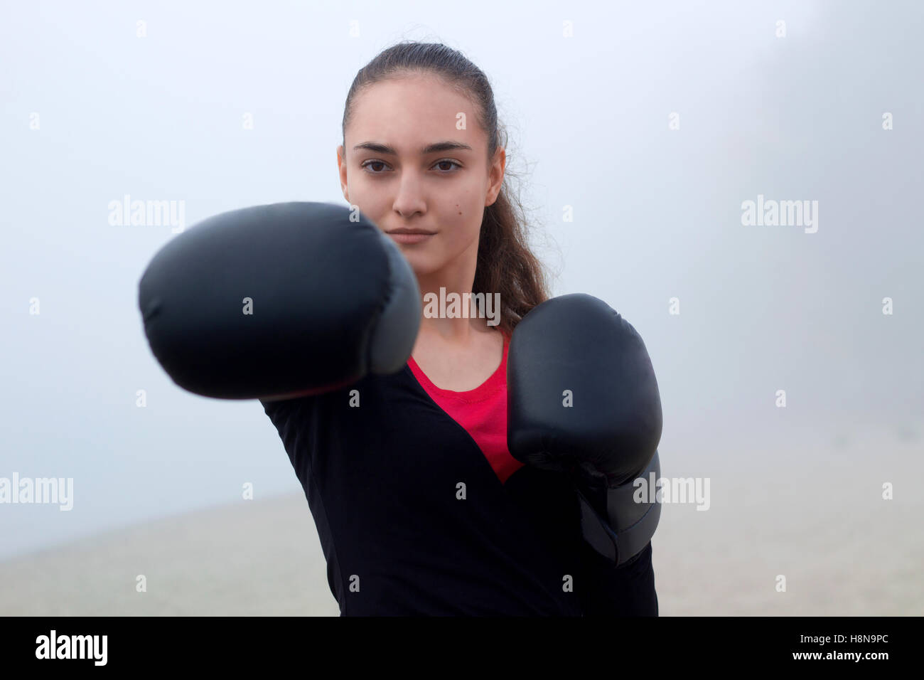 Los jóvenes bastante compacto deportivo de boxeo Fitness mujer hace ejercicios durante el entrenamiento Entrenamiento outdoor Foto de stock