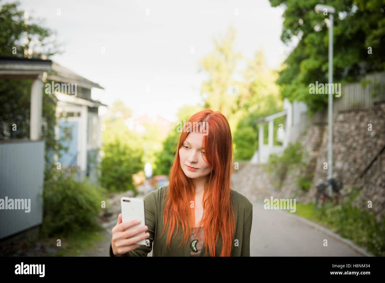Redhaired mujer utilizando el teléfono Foto de stock