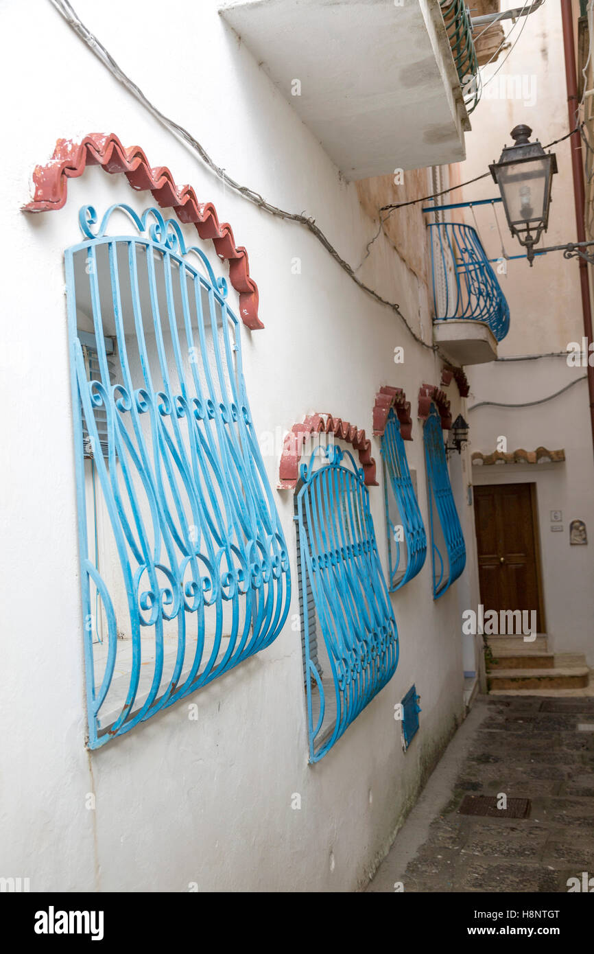 Estrecho pasillo, casas blancas, rejas de ventana azul Fotografía de stock  - Alamy