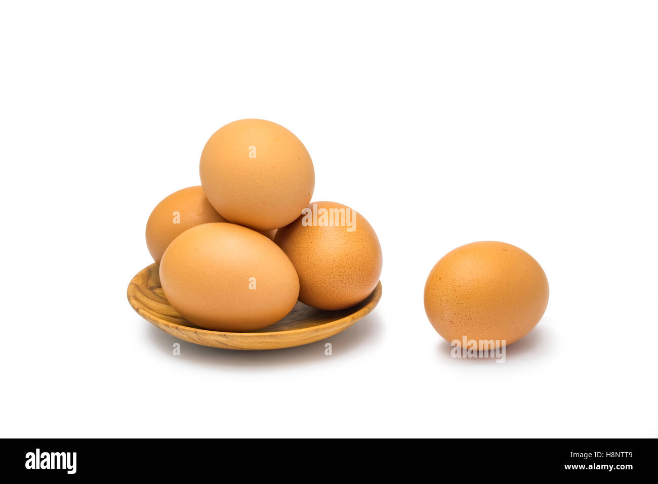 Huevos de gallina en placa de madera sobre fondo blanco. Foto de stock