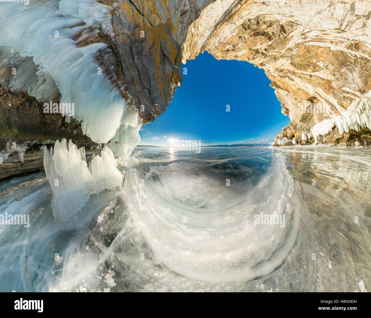 La gruta de hielo en la roca de Olkhon isla en el Lago Baikal cubierto de hielo de ángulo amplio panorama. Foto de stock