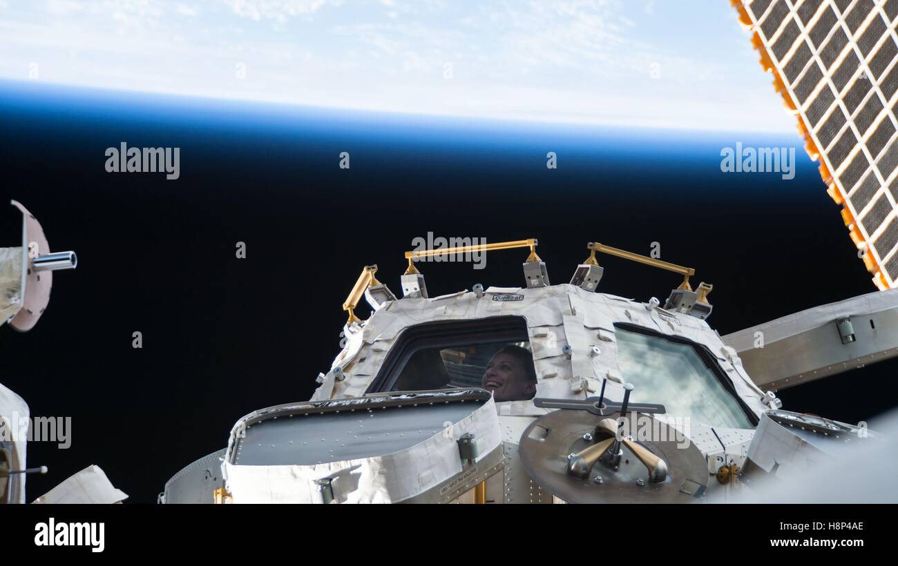 La NASA, astronauta de la Estación Espacial Internacional Kate Rubins parece fuera de una ventana de la iss en el espacio el 9 de octubre de 2016 en la órbita de la tierra. Foto de stock