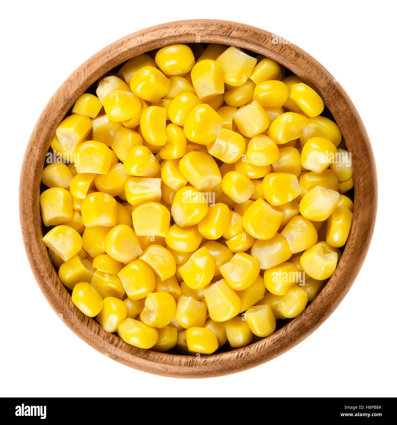 Los granos de maíz dulce en el tazón de madera sobre blanco. Conservas vegetales cocidos amarillo maíz, Zea mays, también llamado azúcar o polo de maíz. Foto de stock