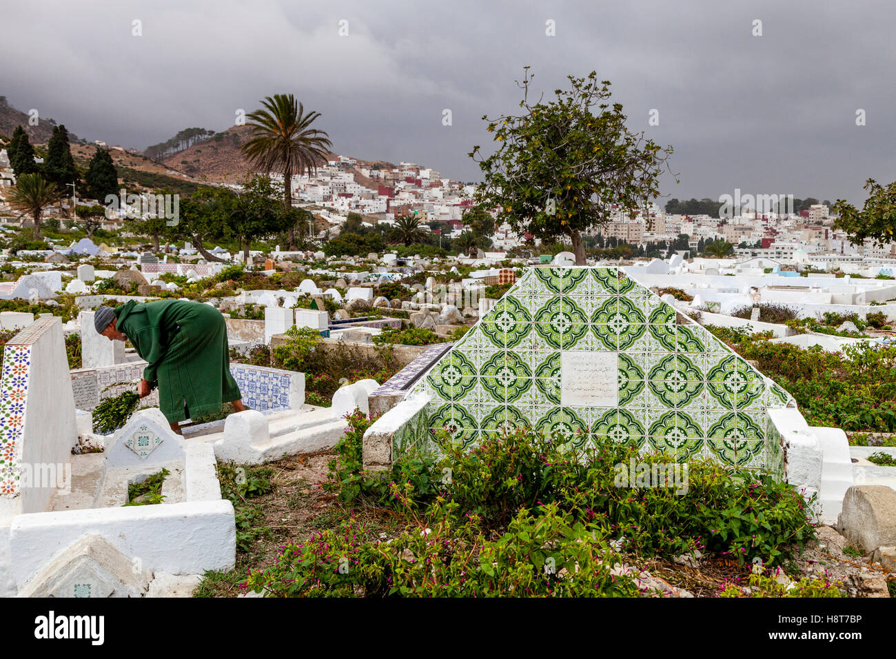 Un hombre Local tendiendo una tumba en el cementerio musulmán, Tetuán, Marruecos Foto de stock