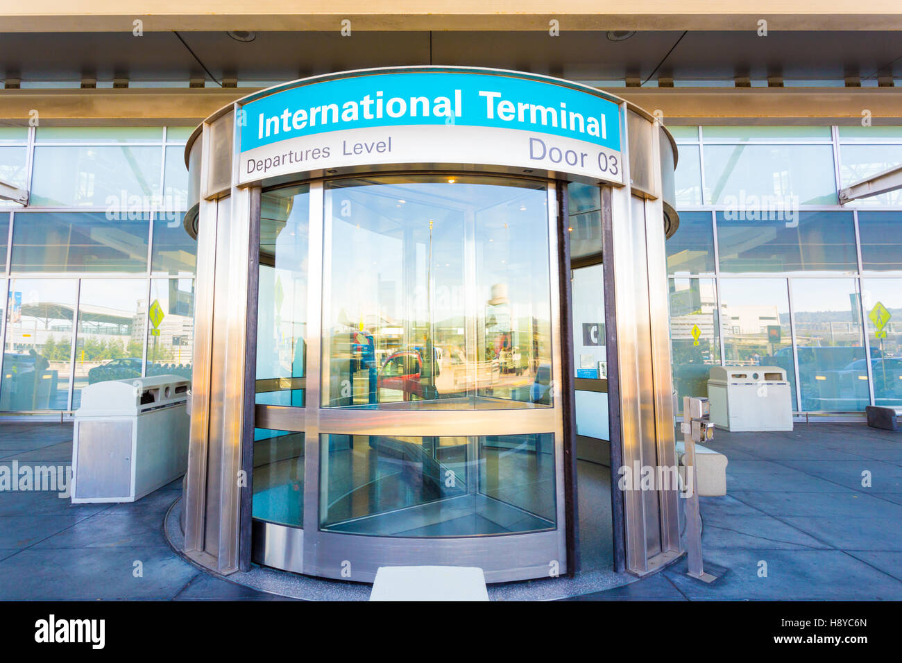 Puerta giratoria delantera proporciona una entrada a la terminal del aeropuerto internacional situado en el nivel de salidas. Horizontal Foto de stock