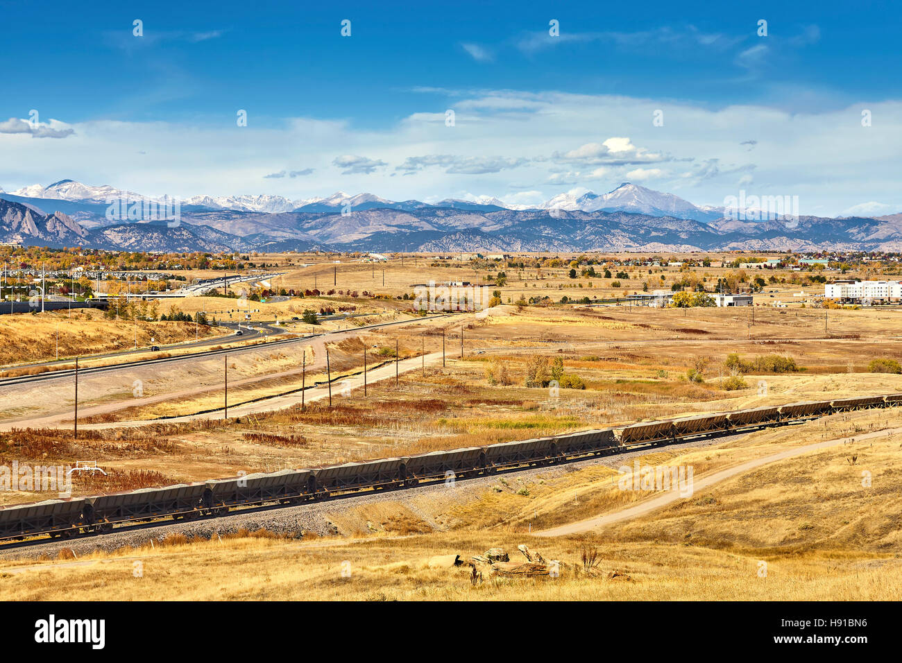Otoño paisaje rural con tren de carga y la distancia de las Montañas Rocosas, Colorado, Estados Unidos. Foto de stock