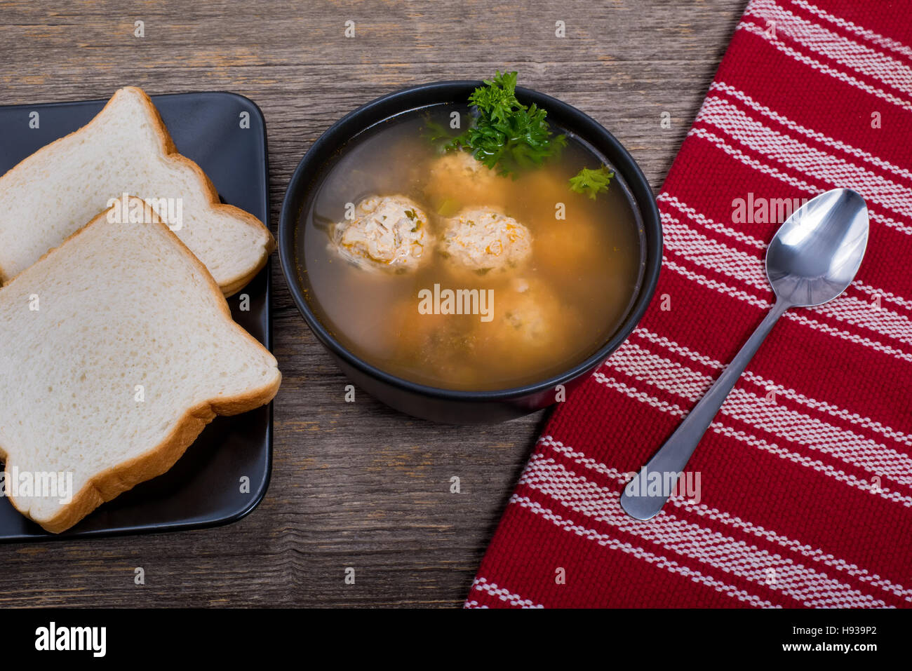 Sopa de Albóndigas con pan en la mesa de luz natural Foto de stock
