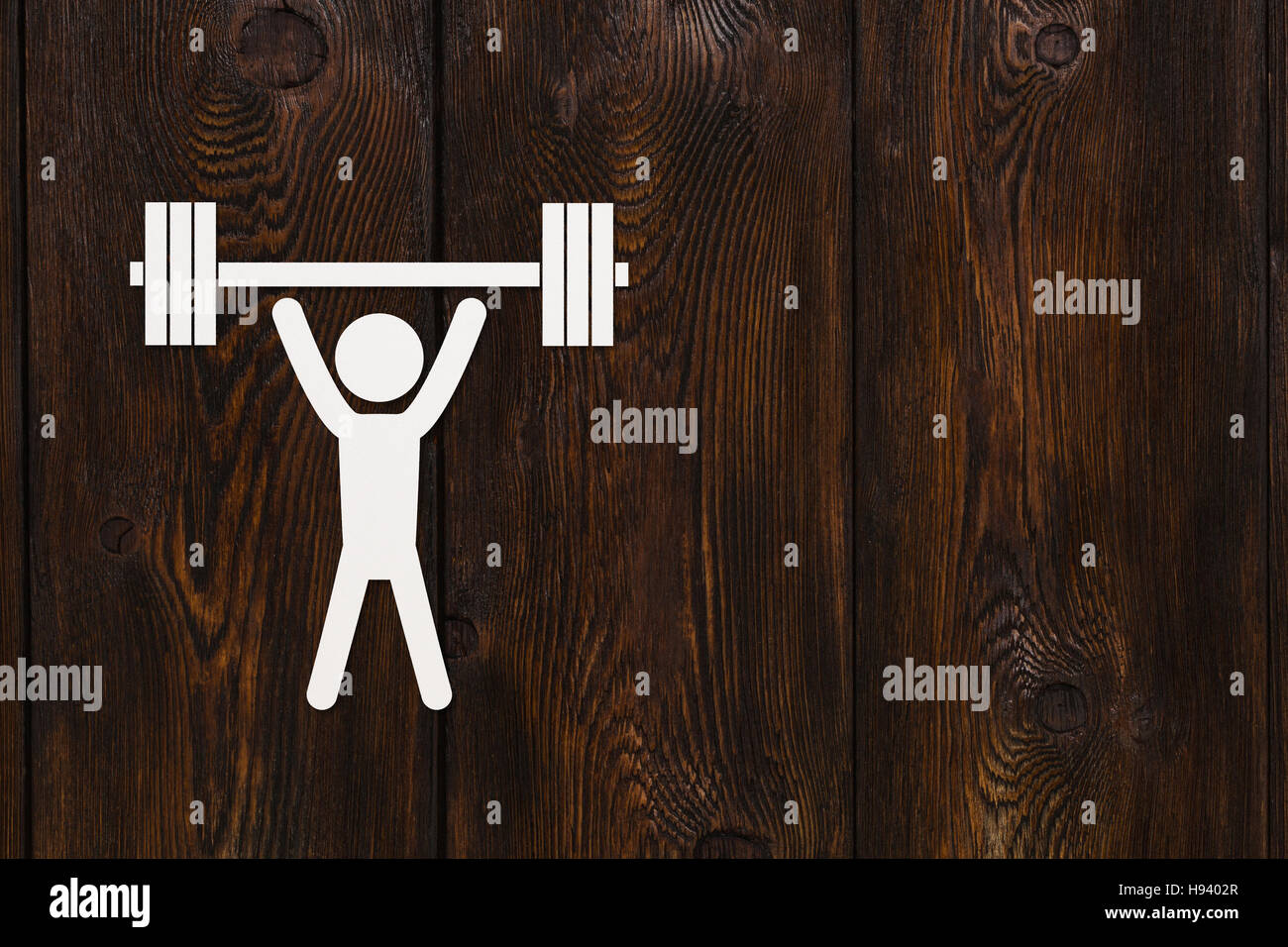 Hombre de papel con pesas. El deporte, el concepto de fitness. Copyspace, fondo de madera Foto de stock