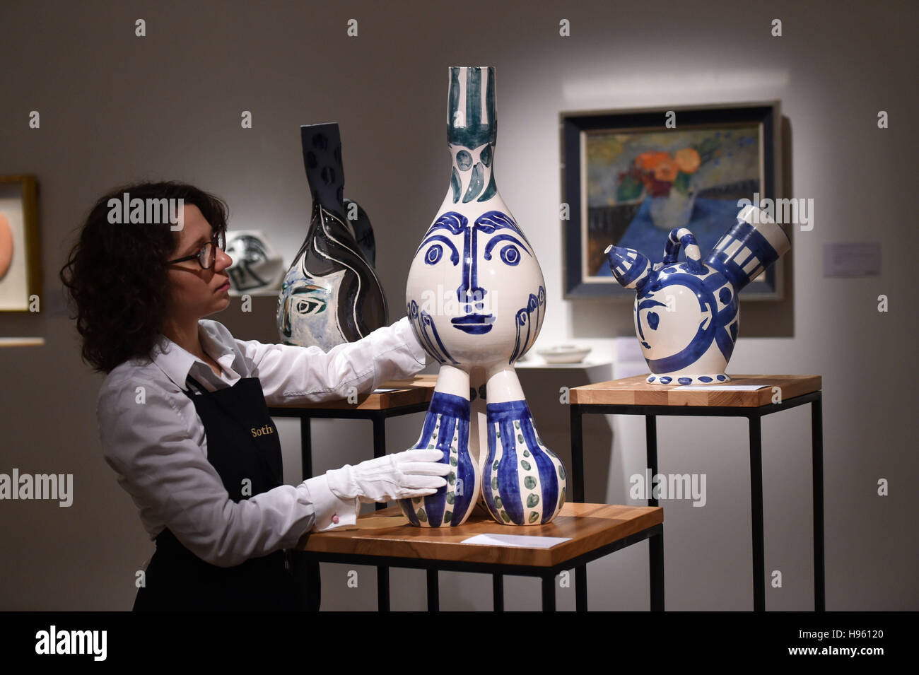 Personal de Sotheby's, Londres, un miembro del personal de Sotheby's ajusta (de izquierda a derecha) Pablo Picasso cerámica titulada Tripode, 1951, Vase Gros Oiseau Vert, 1960 y Visage De Femme, 1951 en A Life in Art: Lord & Lady Attenborough, la célebre colección de productos de cerámica de Picasso y estimada en (de izquierda a derecha) £80.000 - 120.000 libras, £50.000 - £70.000 y £120.000 - 180.000 libras, que forman parte de las próximas subastas de Tesoros Nacionales de Sotheby. Foto de stock