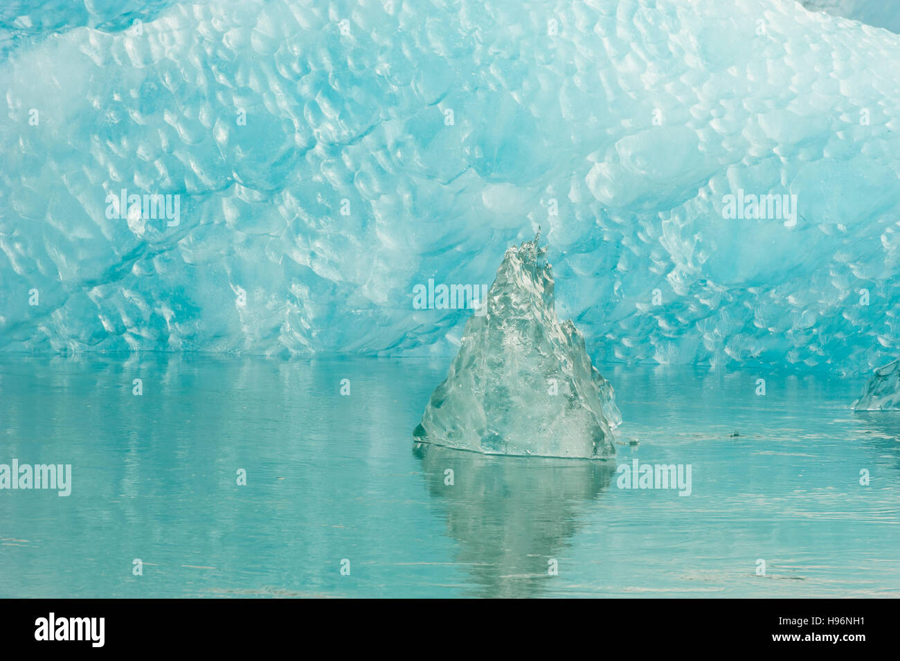 Impacto del cambio climático, un bloque de hielo rodeado de hielo claro en el agua que fluye Foto de stock