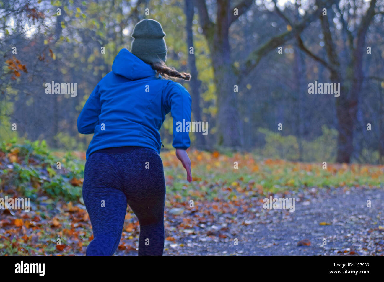 Mujer joven corriendo en el parque de otoño. Foto de stock