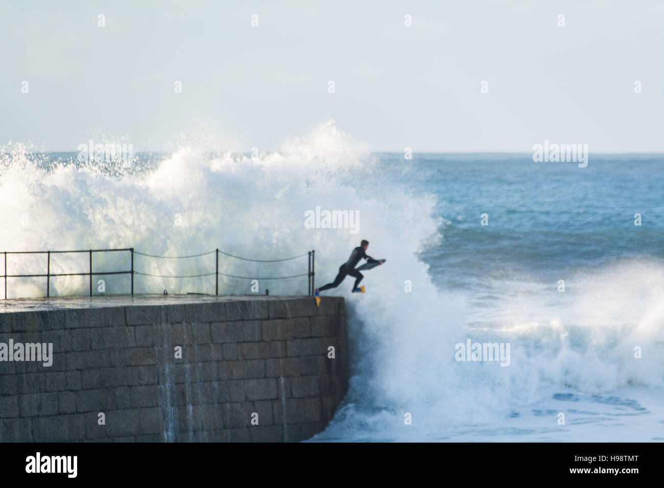 Porthleven, Cornualles, en el Reino Unido. 20 de noviembre de 2016. El clima del Reino Unido. Los surfistas teniendo arriesgada en ruta hacia el mar después de la tormenta Porthleven Angus pasa de Cornualles. El espigón en el puerto de entrada está normalmente cerrada durante un tiempo tormentoso como varias personas han sido asesinadas en el pasado por ser lavadas. Crédito: Simon Maycock/Alamy Live News Foto de stock