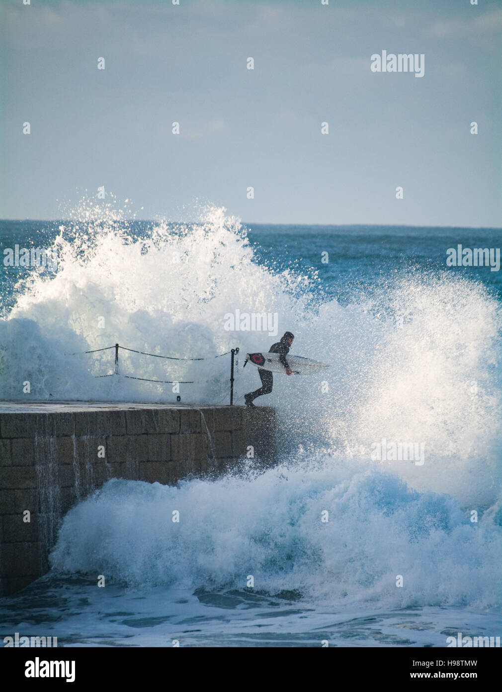 Porthleven, Cornualles, en el Reino Unido. 20 de noviembre de 2016. El clima del Reino Unido. Los surfistas teniendo arriesgada en ruta hacia el mar después de la tormenta Porthleven Angus pasa de Cornualles. El espigón en el puerto de entrada está normalmente cerrada durante un tiempo tormentoso como varias personas han sido asesinadas en el pasado por ser lavadas. Crédito: Simon Maycock/Alamy Live News Foto de stock