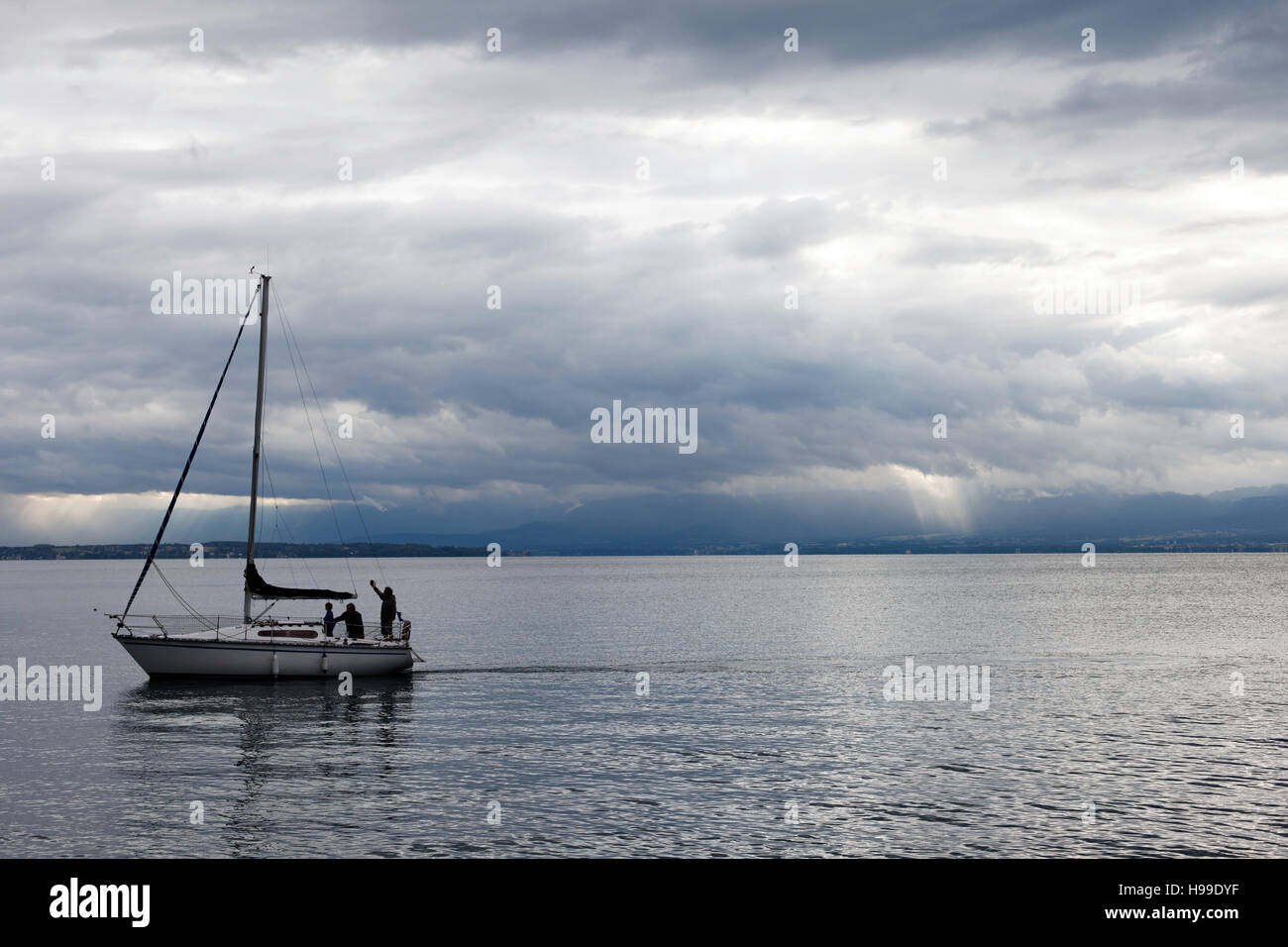 Tres personas en un yate de vela, el lago de Ginebra. Foto de stock