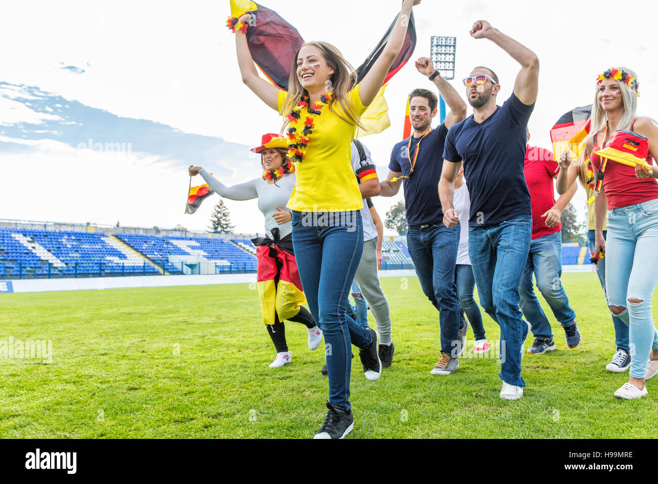 Grupo de aficionados al fútbol se ejecutan en campo de fútbol Foto de stock