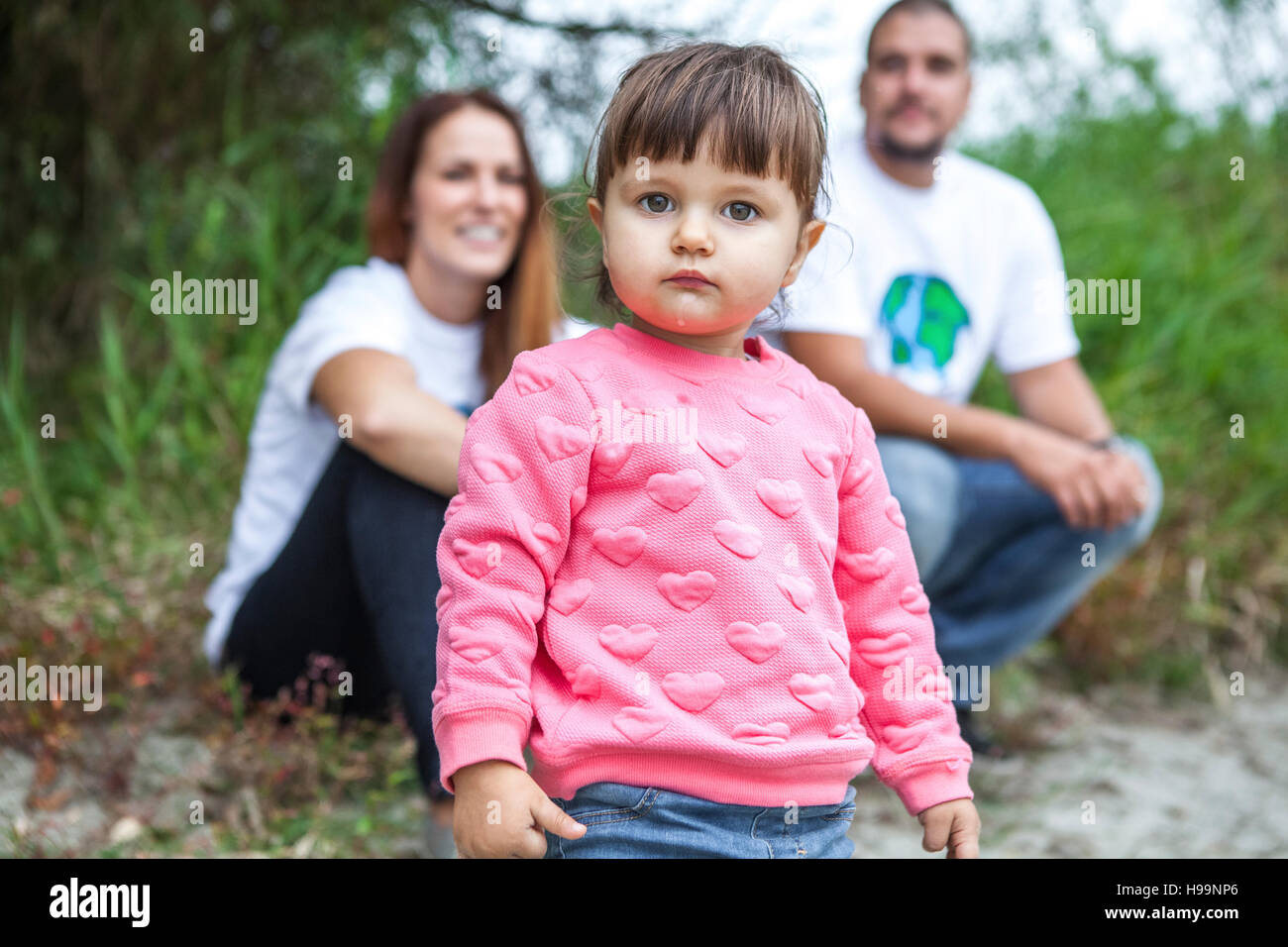 Niño Niña con padres en segundo plano. Foto de stock