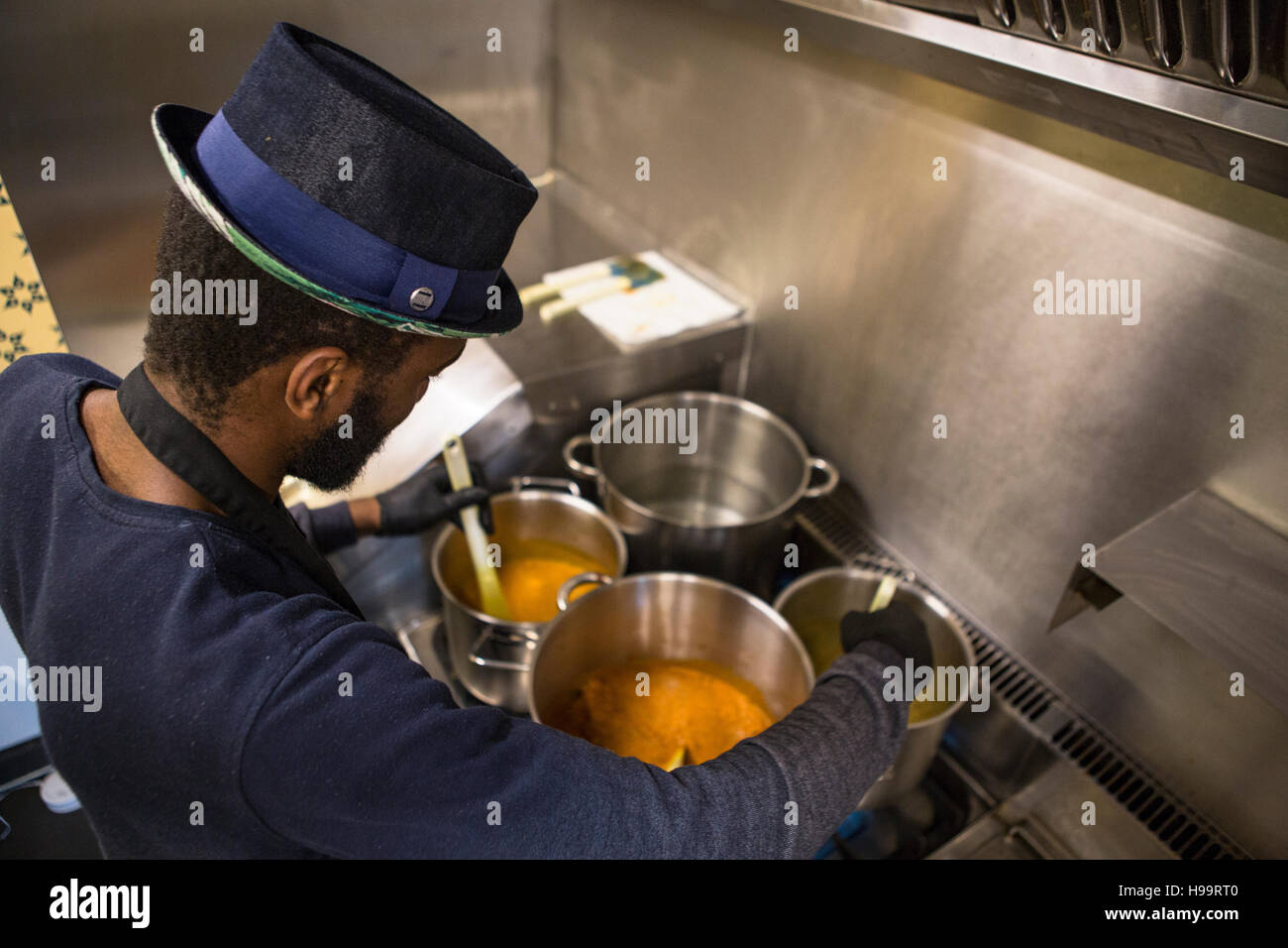 Hombre con sombrero cocinar en la cocina comercial de camión de alimentos Foto de stock