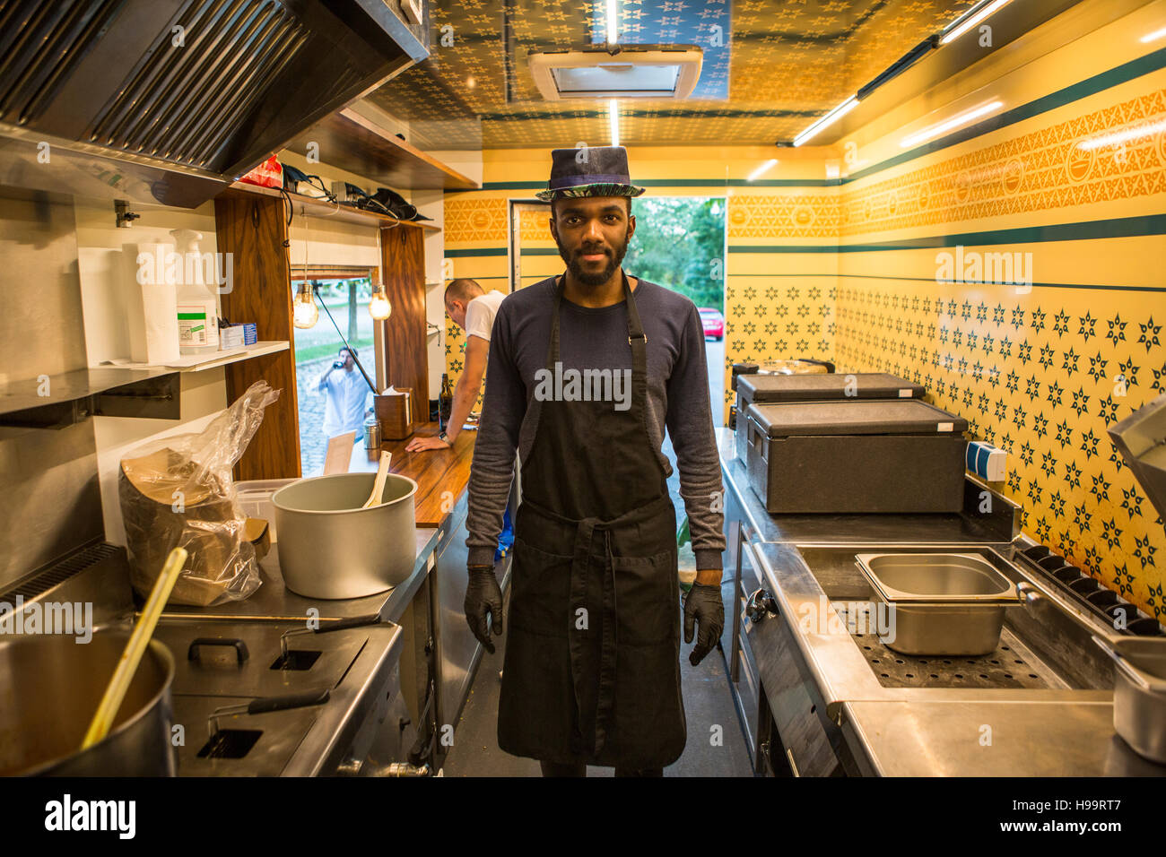 Hombre con sombrero y delantal de cocina comercial de camión de alimentos Foto de stock