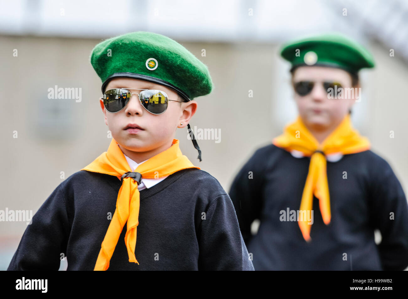 Belfast, Irlanda del 13 Nov 2016 - Niños disfrazados de pseudo-uniformes paramilitares incluidos boinas verdes, cuello bufandas, camisetas blancas, puentes y llevar gafas sol reflejados participar en un