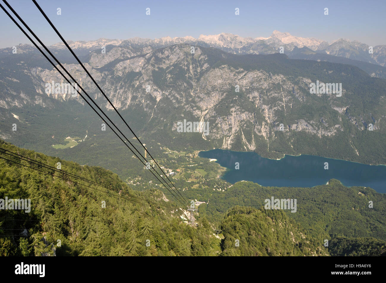 Mirando hacia abajo el teleférico alpino hasta el pueblo de Ukanc en la orilla del lago Bohinj, Eslovenia, desde el Monte Vogel Foto de stock