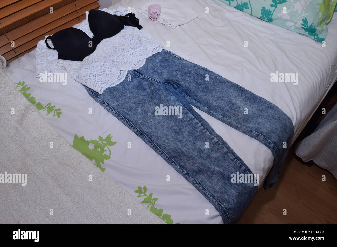 Femenina sentado sobre una cama Fotografía de stock - Alamy