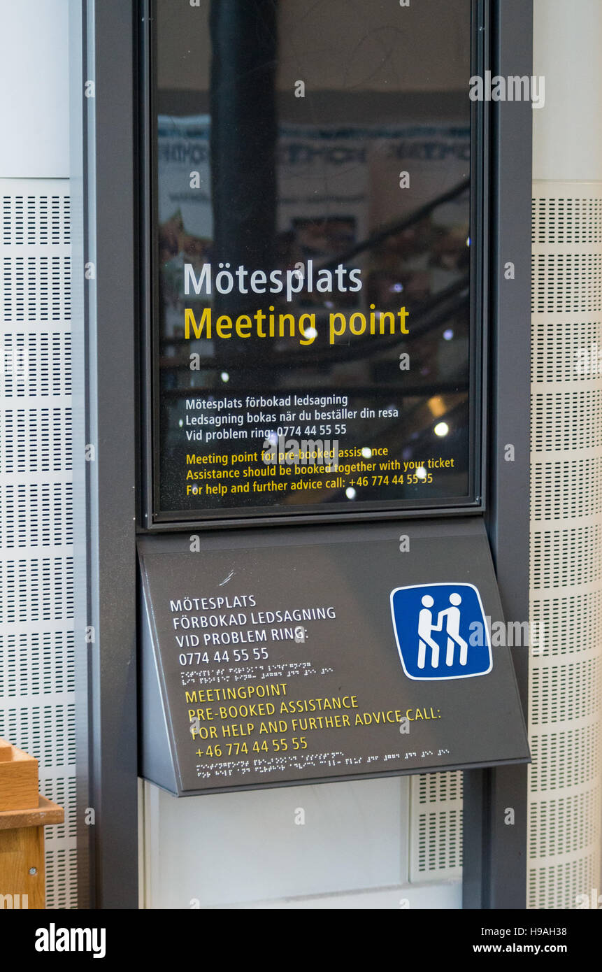 Signo de la información en una estación de tren, donde las personas con discapacidad que necesiten asistencia pueden esperar para pre-reservar asistencia Foto de stock