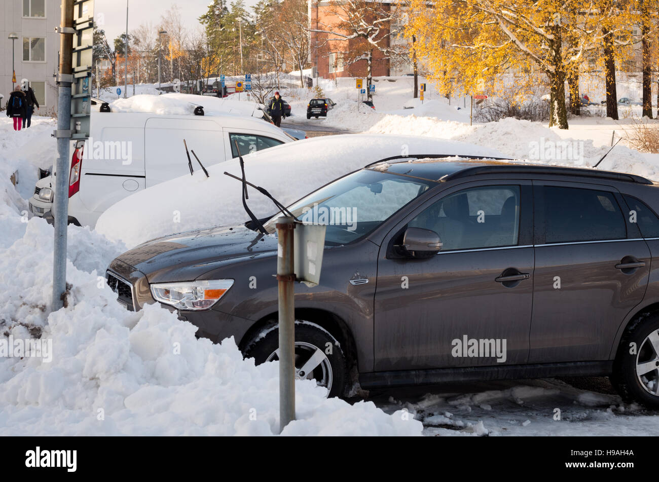 Los coches aparcados cubiertos de nieve después de una tormenta de nieve a principios de noviembre Foto de stock