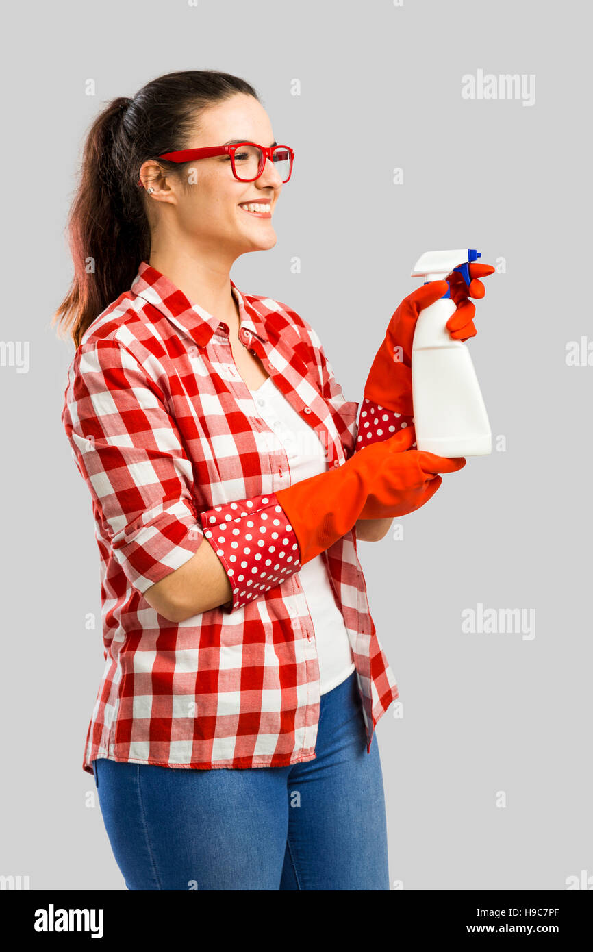 Pretty Woman guantes y sosteniendo un aerosol limpiador Foto de stock