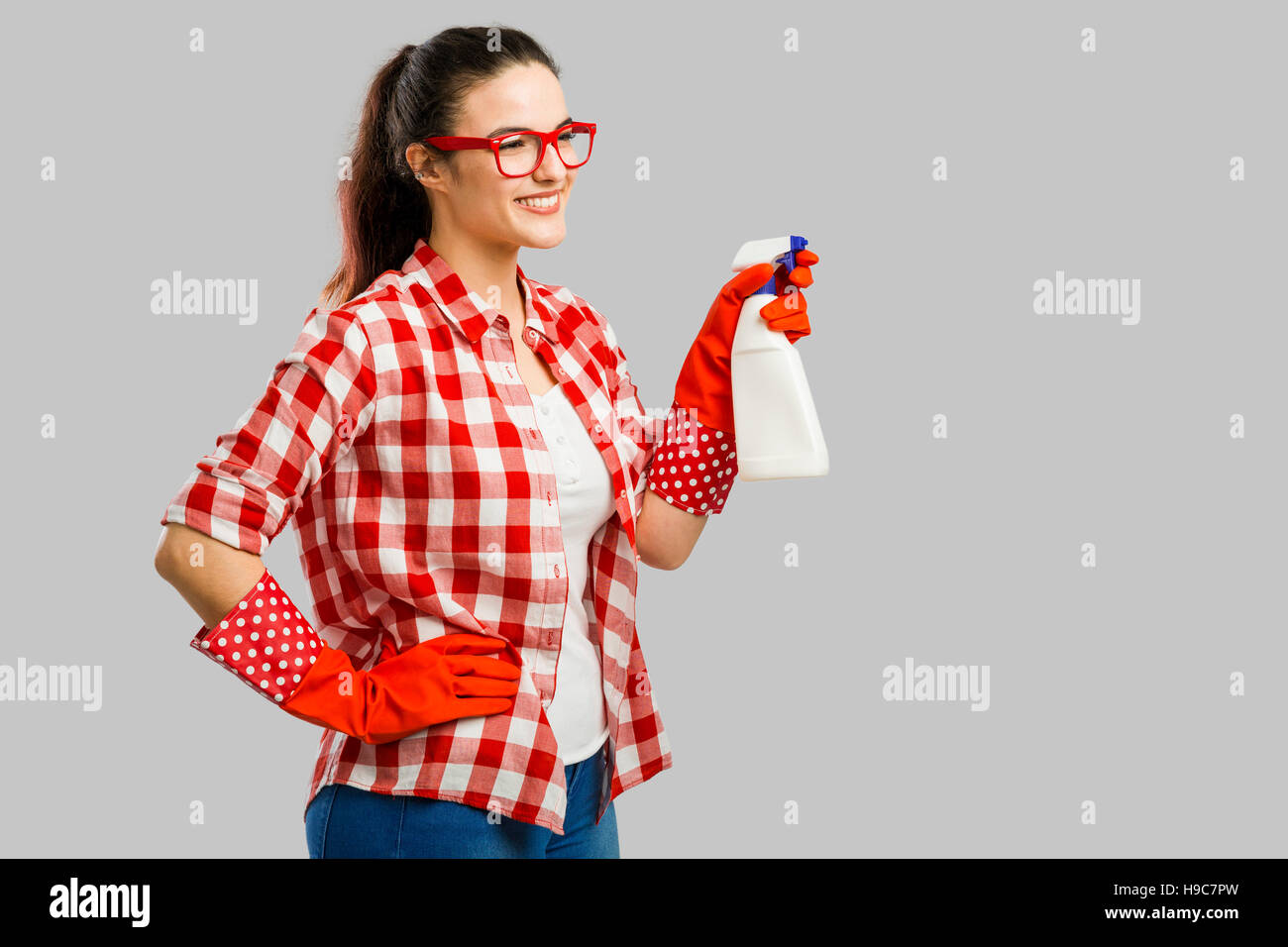 Pretty Woman guantes y sosteniendo un aerosol limpiador Foto de stock
