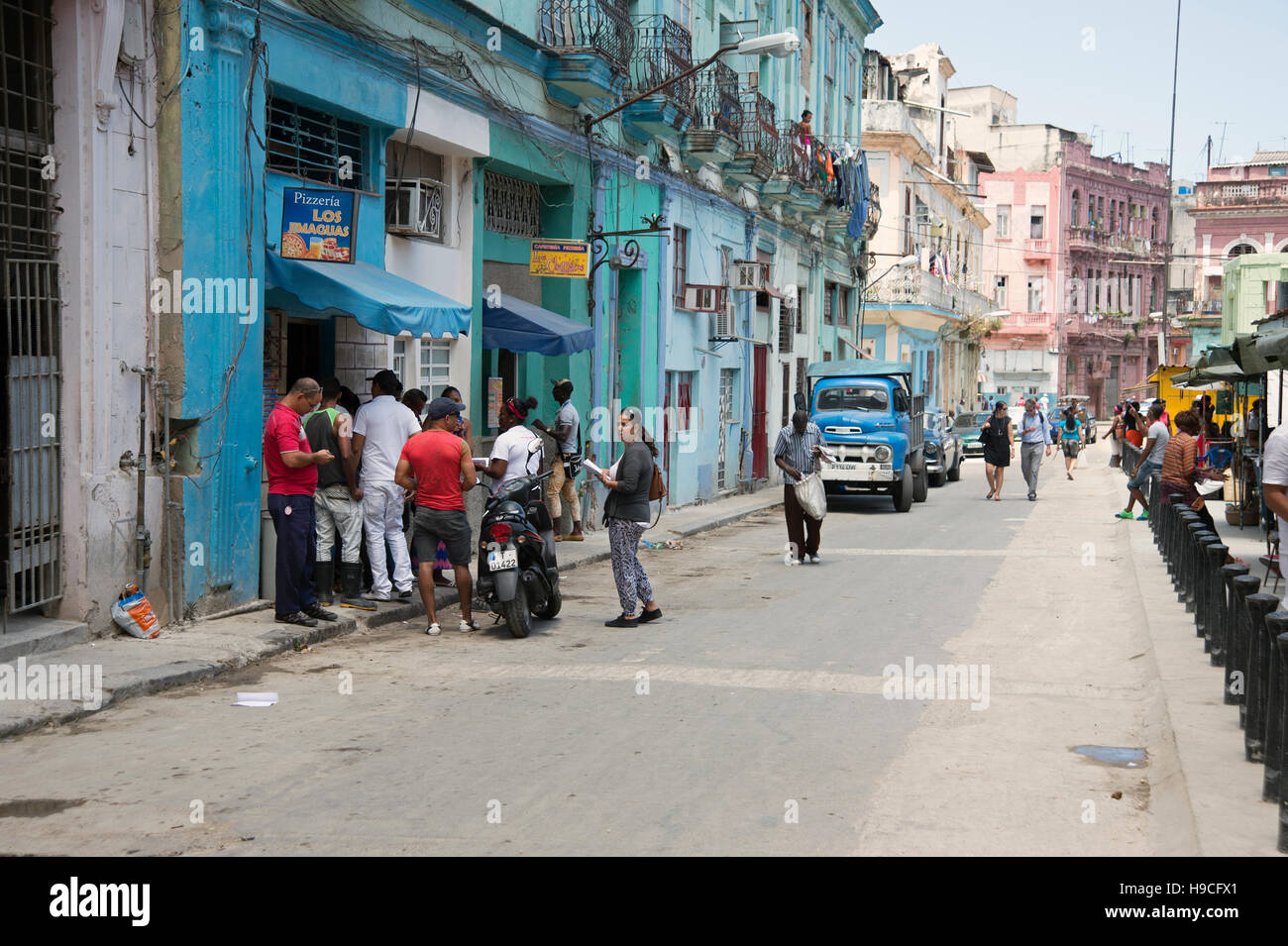 Los cubanos cola para pizza en desmenuzar desvencijado street en el centro de La Habana Cuba Foto de stock