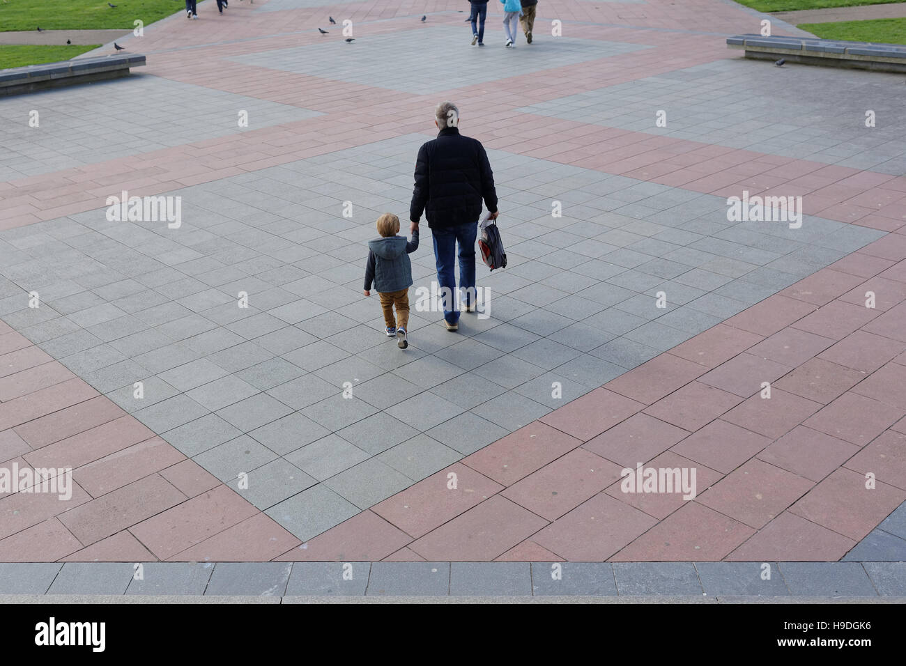 Padre e hijo cogidos de la mano en un paisaje urbano moderno gráfico urbano Foto de stock