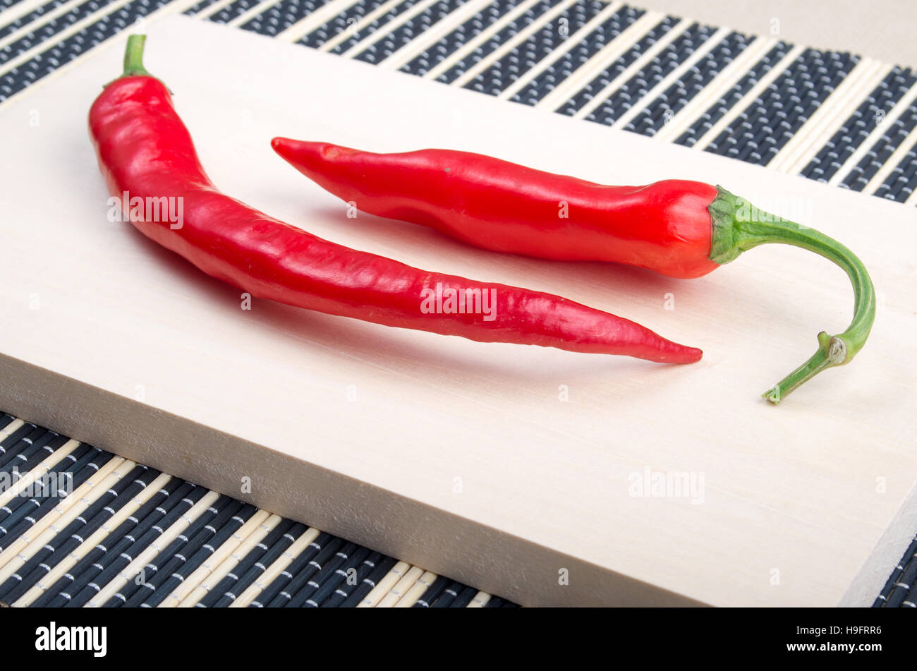 Dos red hot chili peppers closeup sobre fondo de madera Foto de stock