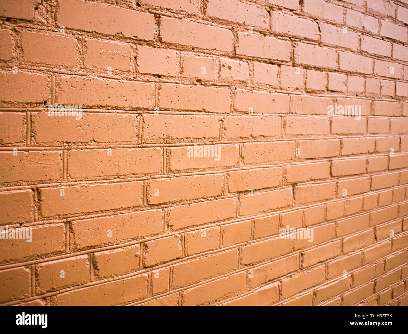 Ángulo de visión sobre la pared de ladrillo pintado de pintura roja. Foto de stock