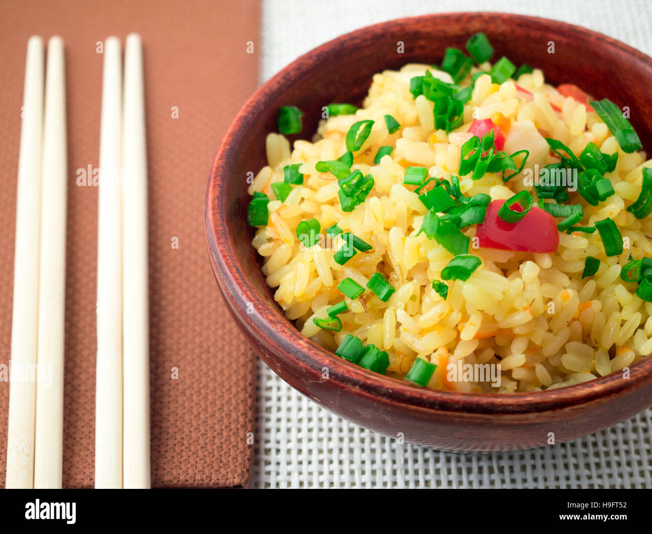 Wooden bowl de arroz cocido y las verduras en un paño de cerca con poca profundidad de enfoque. Foto de stock