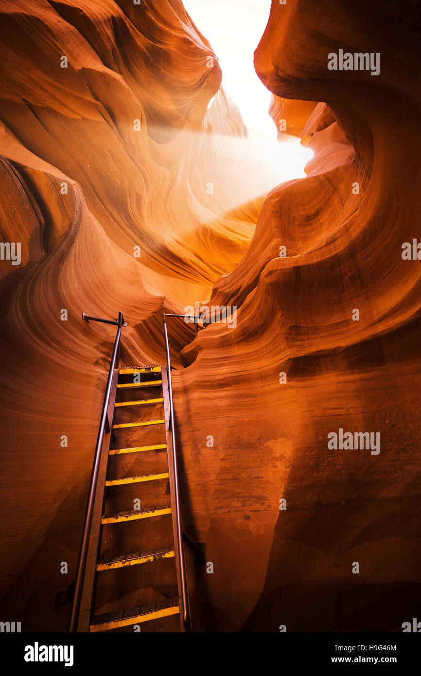 Impresionantes formaciones de arenisca con una escalera que conduce hacia un rayo de luz mágica en el famoso Antelope Canyon, Arizona, EE.UU. Foto de stock