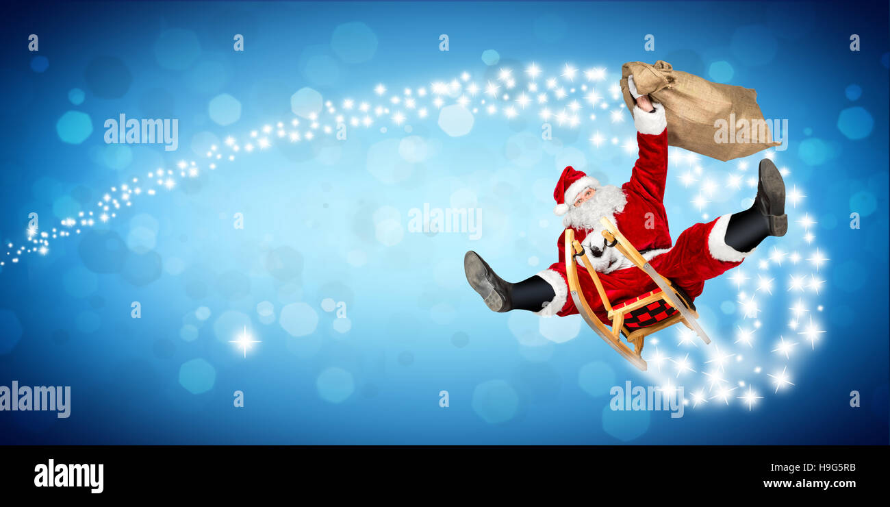 Crazy santa claus en su trineo hilarante fast funny crazy xmas regalo de navidad entrega amplio panorama bokeh de fondo azul Foto de stock