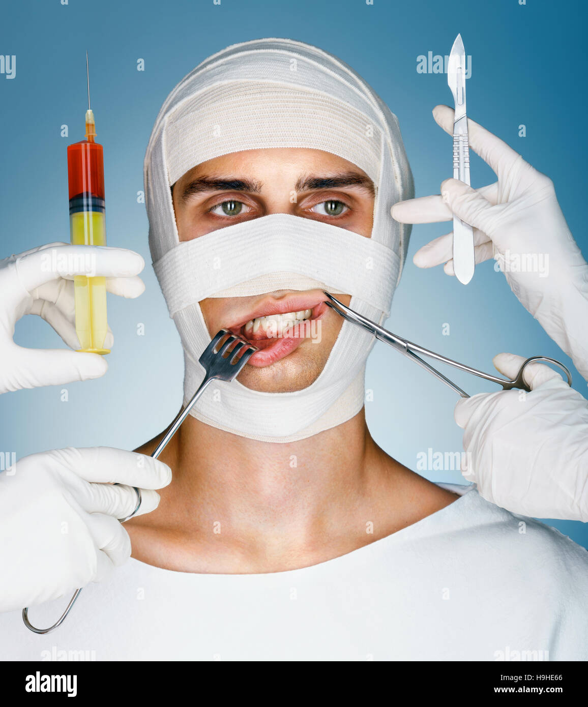 Víctima de la cirugía plástica. Hombre envuelto en vendajes médicos mientras doctores con jeringas, cierre quirúrgico, gancho y escalpelos cerca de su cara. Concepto de belleza Foto de stock