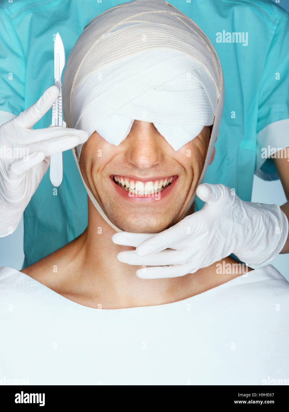 Hombre sonriente tras operación de cosmética. Cerca de cara vendada después de la cirugía plástica. Cara de belleza Foto de stock