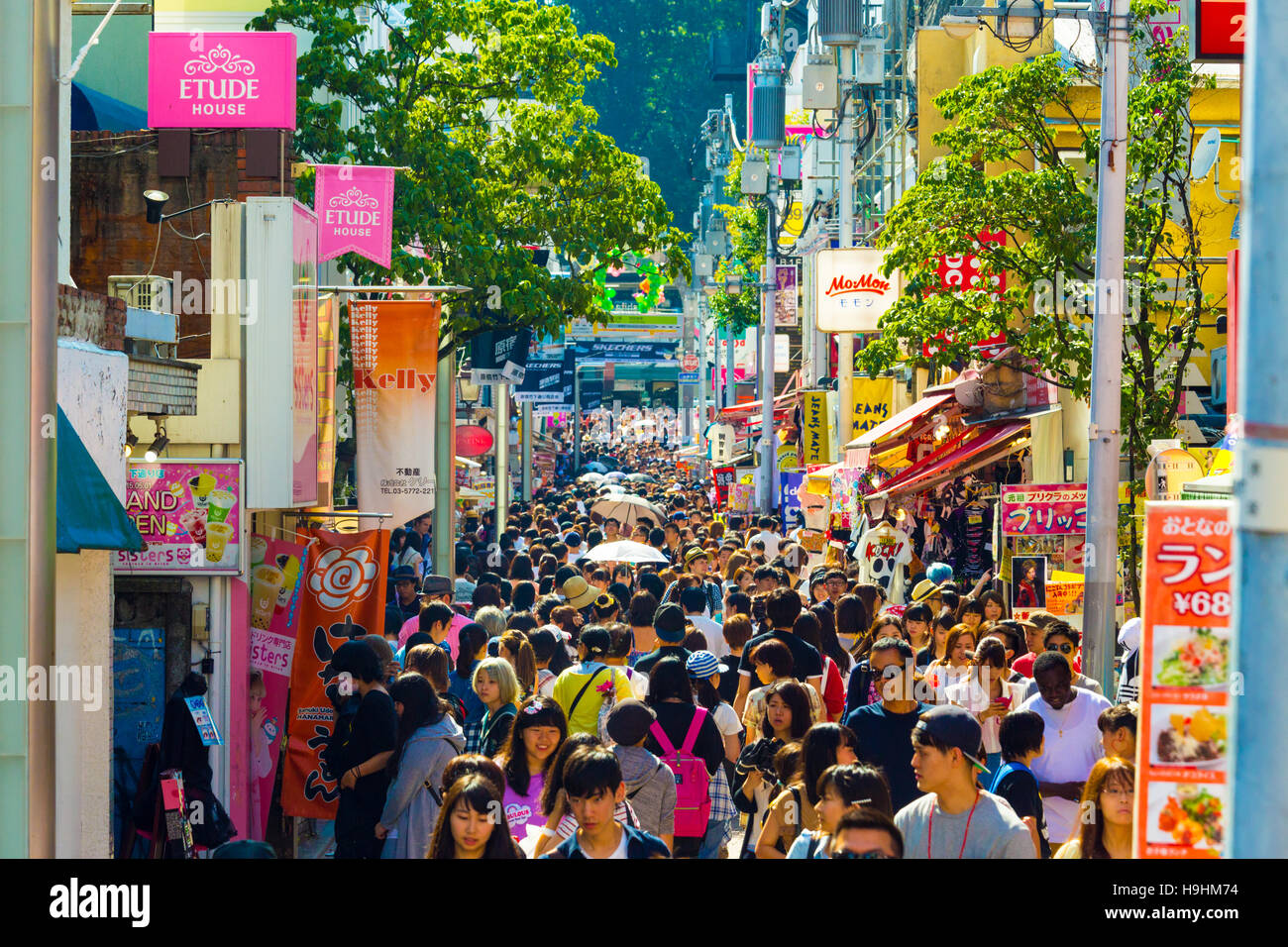 Muchos jóvenes caminando por hacinados y bulliciosa calle comercial de consumismo meca bordeada con tiendas en la concurrida Takeshita Dor Foto de stock