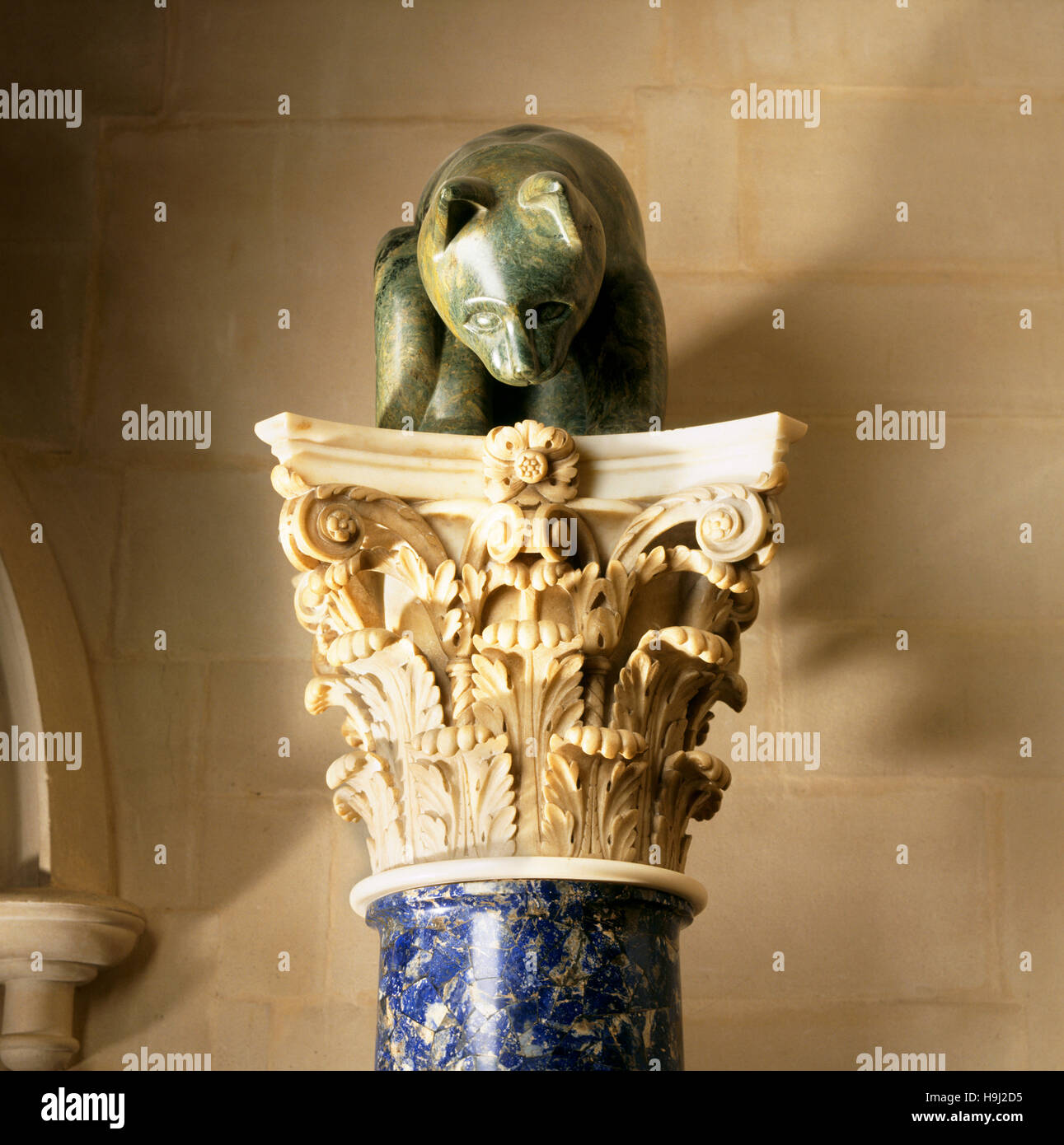 Un gato de esteatita mira hacia abajo desde uno de los italianos del siglo XVIII las columnas con capiteles corintios y ejes enchapados con lapislázuli. Foto de stock