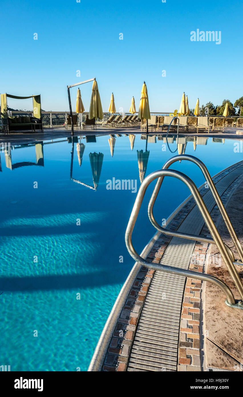 Una vista de cerca de una piscina en Hyatt Aviara Resort, con reflejos de la sombrilla en el sol de la mañana Foto de stock