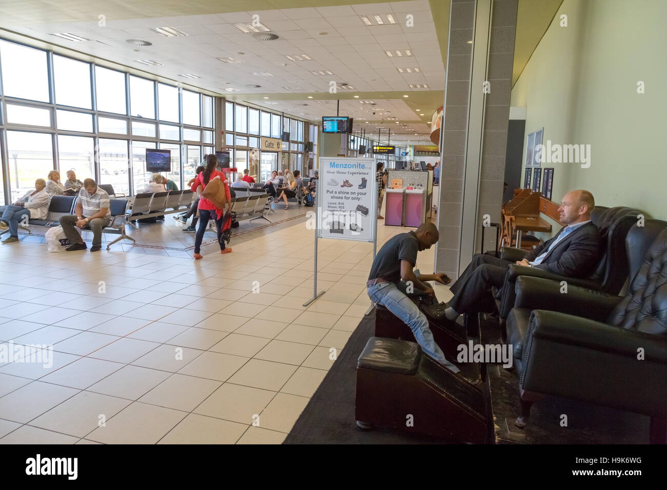 Limpiabotas, sala de embarque, el aeropuerto internacional de Port Elizabeth, Sudáfrica Foto de stock