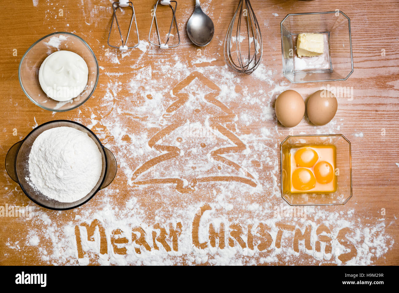 Pastel ingredientes, batidor de huevos, los huevos, la crema y la harina. ¡Feliz Navidad! Foto de stock
